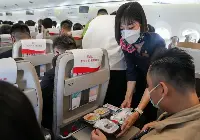 Hostess serve del cibo sul primo volo commerciale di un aereo cinese Comac C-919 operato con passeggeri il 28 maggio 2023 da China Eastern Airlines