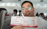 Passeggero mostra biglietto aereo a bordo del primo volo commerciale di un velivolo cinese Comac C-919 operato con passeggeri il 28 maggio 2023 da China Eastern Airlines