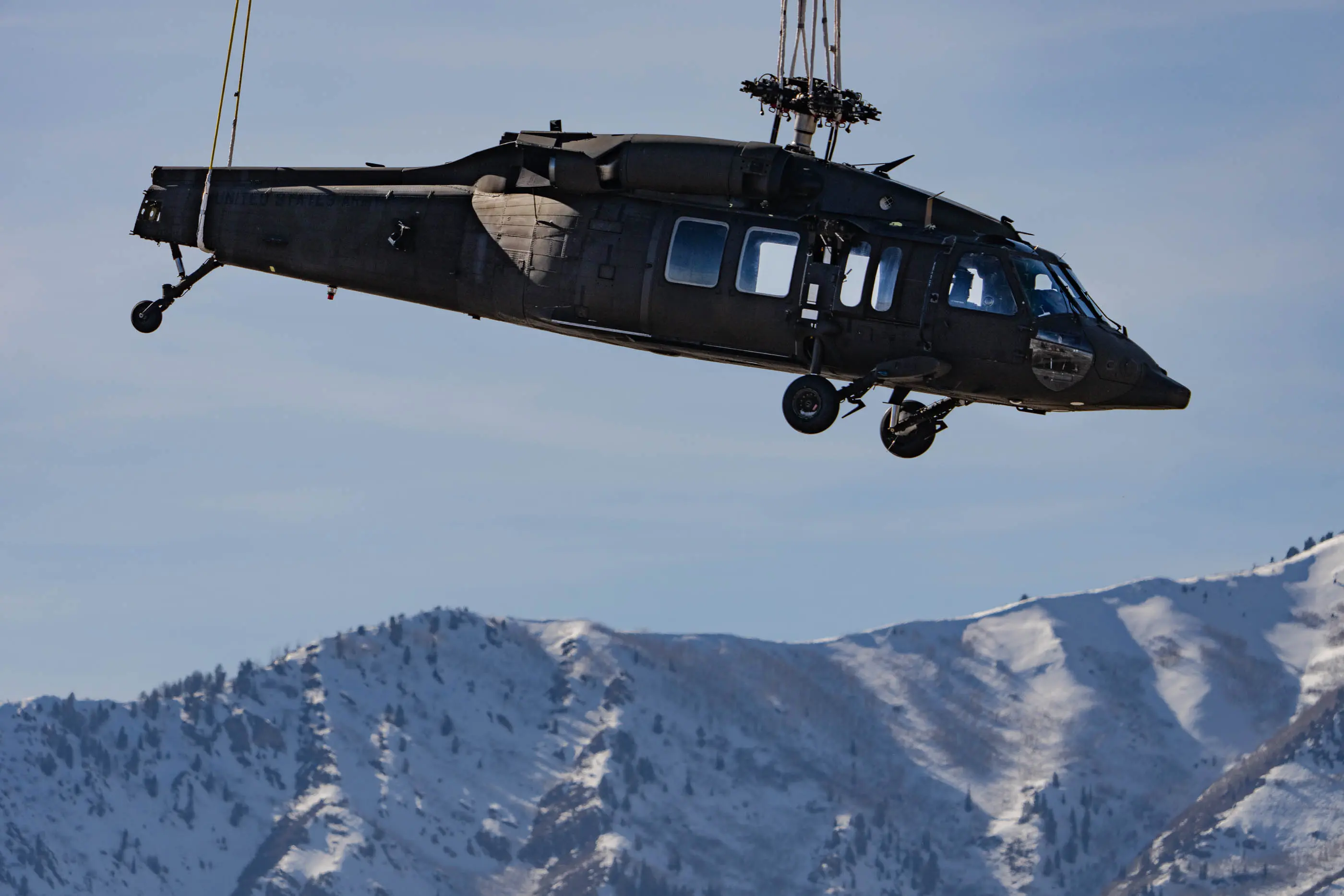 Un elicottero Black Hawk incidentato che viene trasportato da un aeromobile Chinook