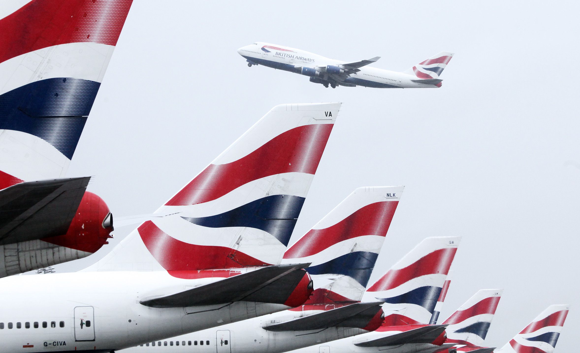 Code di aerei di British Airways e sullo sfondo un Boeing B-747/400 in decollo