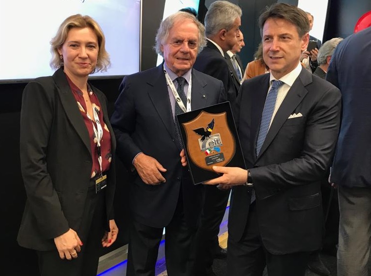 "Parigi-Le Bourget 2019". Da sinistra: Domitilla Benigni, direttore generale di Elettronica ed Enzo Benigni (presidente e ceo) consegnano crest Elt a Giuseppe Conte