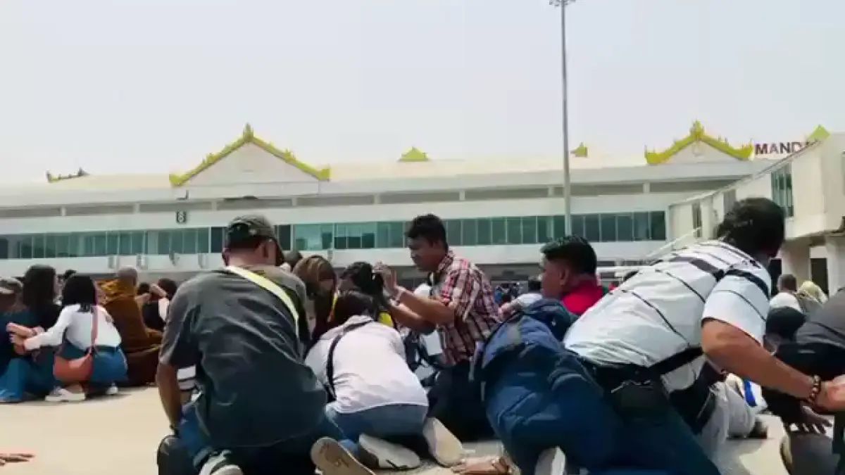 Terremoto magnitudo 7.7 del 28 marzo 2025: passeggeri in attesa all'aeroporto di Mandalay, Myanmar, si mettono al riparo sulla pista dello scalo