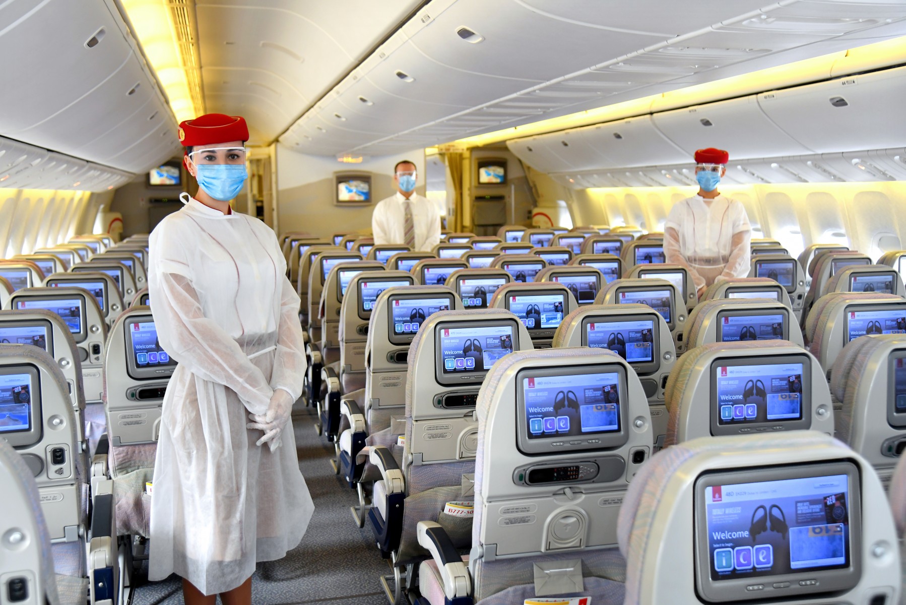 Equipaggio Emirates a bordo indossa camici sopra le divise, oltre a guanti, maschere e visiere