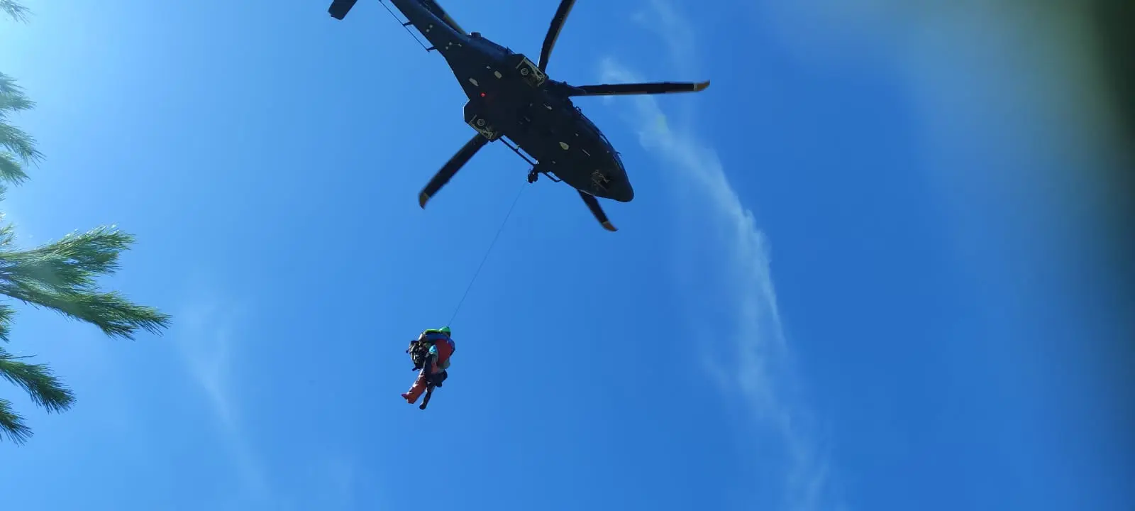 Elicottero AMI in volo durante una operazione di soccorso tramite verricello