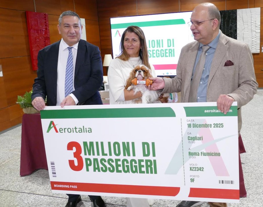 Cagliari, 18 dicembre 2025. Massimo Di Perna, cco Aeroitalia (a sinistra) e Gaetano Intrieri (ad Aeroitalia) hanno festeggiato all'aeroporto "Mario Mameli" i tre milioni di biglietti venduti dalla compagnia insieme alla 3 milionesima passeggera, Alessia Vargiu, in partenza oggi per Fiumicino con la sua amica a quattro zampe Chloe; per lei tre biglietti aerei per viaggiare ancora assieme, in cabina e con il massimo comfort, sui voli Aeroitalia