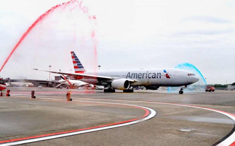 Il particolare (getti colorati simbolo compagnia AA) e tradizionale semicerchio d’acqua per festeggiare i dieci anni del volo American da Malpensa a New York