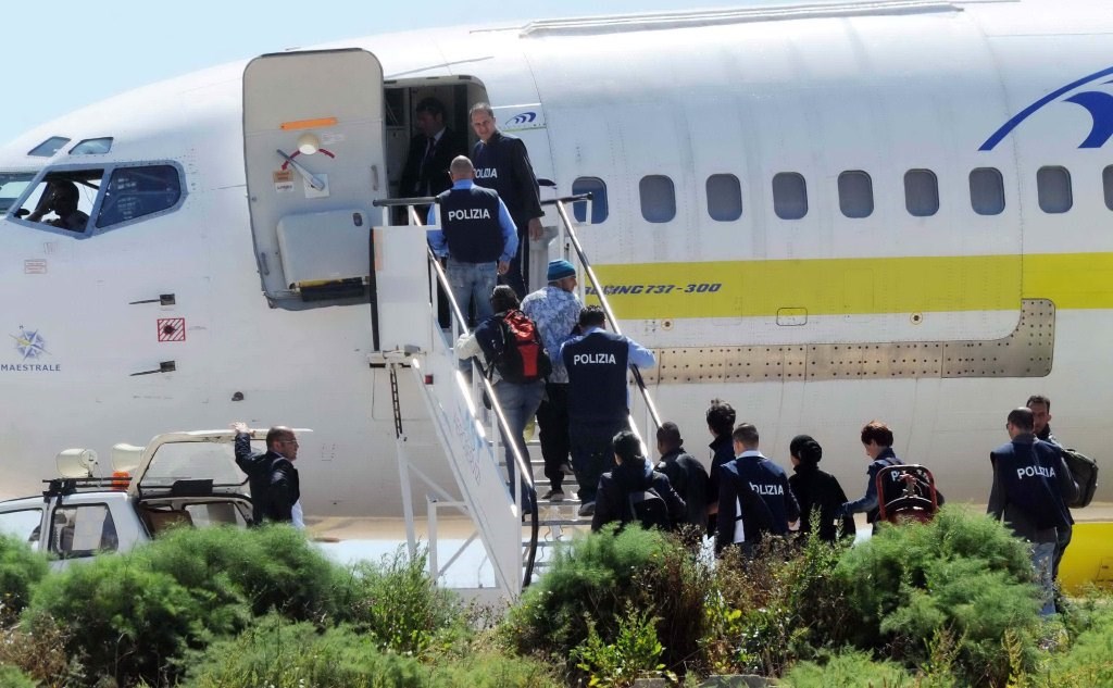 Foto d'archivio di poliziotti che salgono su un aereo che rimpatrierà degli immigrati clandestini