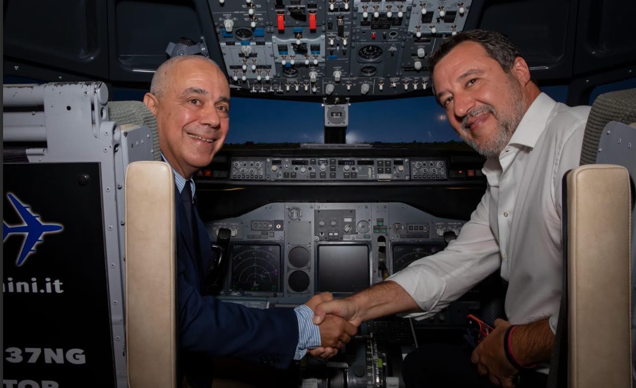 Rimini, 25 agosto 2026. Il vicepremier Salvini ad uno dei tre simulatori di volo presenti nello stand Enac, B-737, nel corso del Meeting (21-26 agosto) affiancato in cabina di pilotaggio dal vicedirettore generale Enac Fabio Nicolai