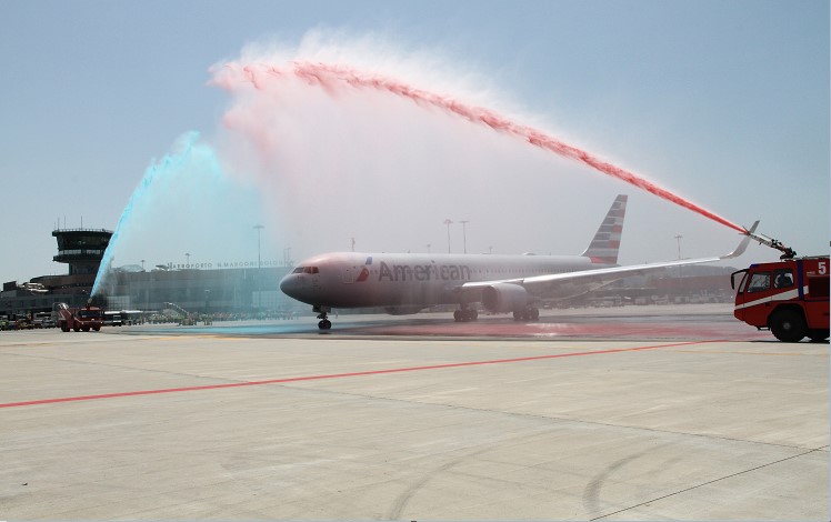 Aereo AA riceve il battesimo dell'acqua per il nuovo volo diretto in partenza da Bologna a Philadelphia con i fumi colorati di American Airlines